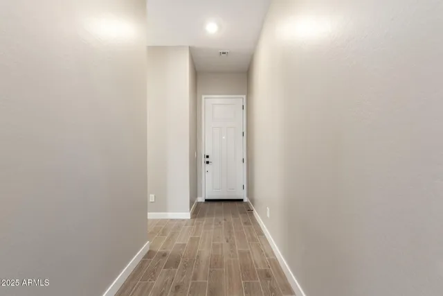 a view of a hallway with wooden floor