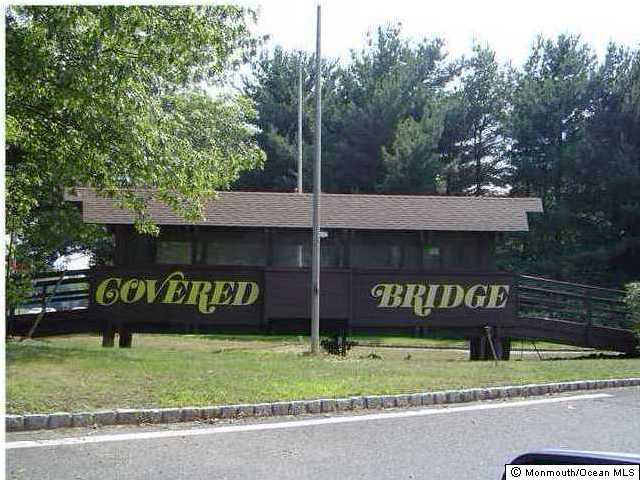 58 Amberly Drive, Unit C Manalapan, NJ 07726 - Photo 2 of 3 a view of a park that has sign board