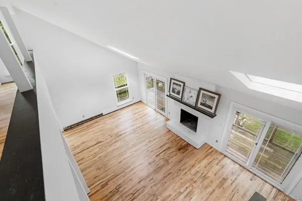 a view of a livingroom with wooden floor and a fireplace