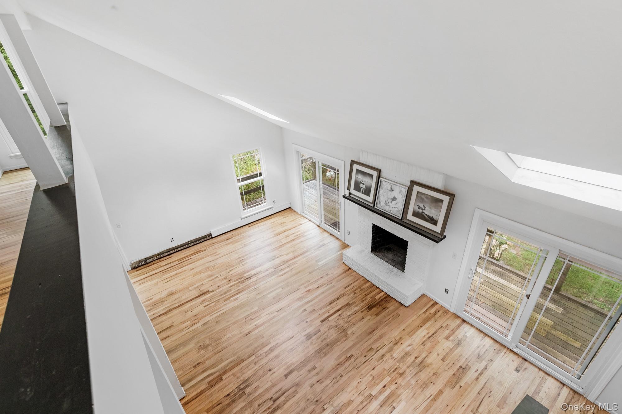 18 Norfolk Drive Springs, NY 11937 - Photo 11 of 26 a view of a livingroom with wooden floor and a fireplace