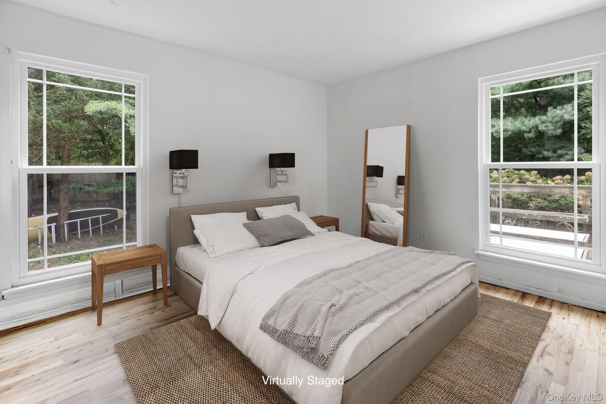 18 Norfolk Drive Springs, NY 11937 - Photo 8 of 26 a bedroom with a large bed and a large window