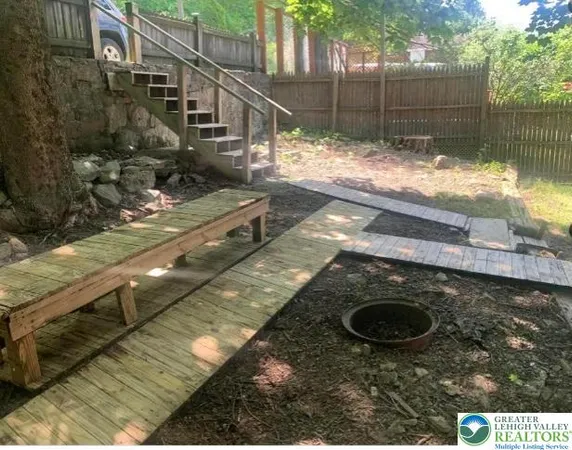 a view of a backyard with wooden fence