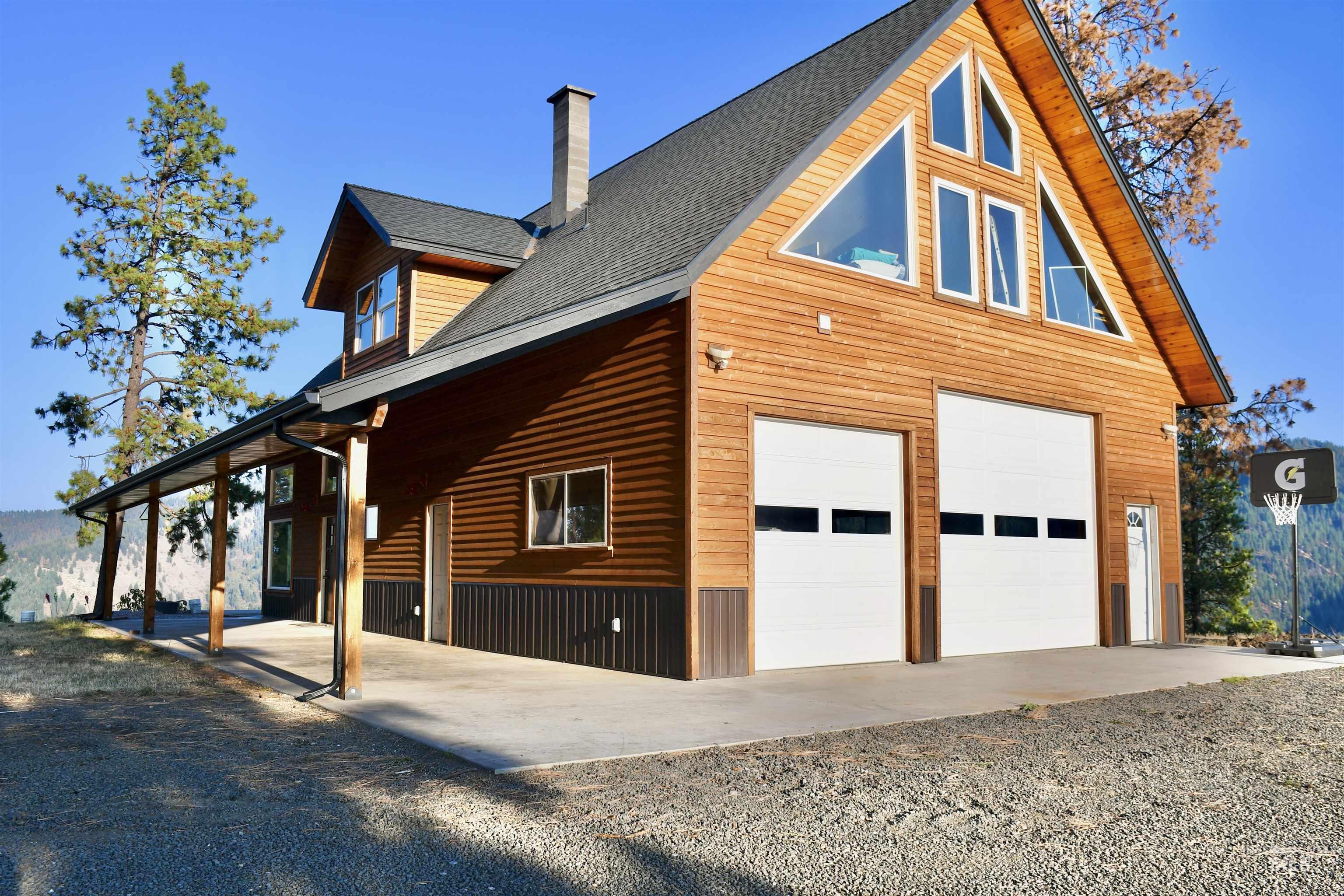 View of property exterior featuring roof with shingles, a chimney, and a garage