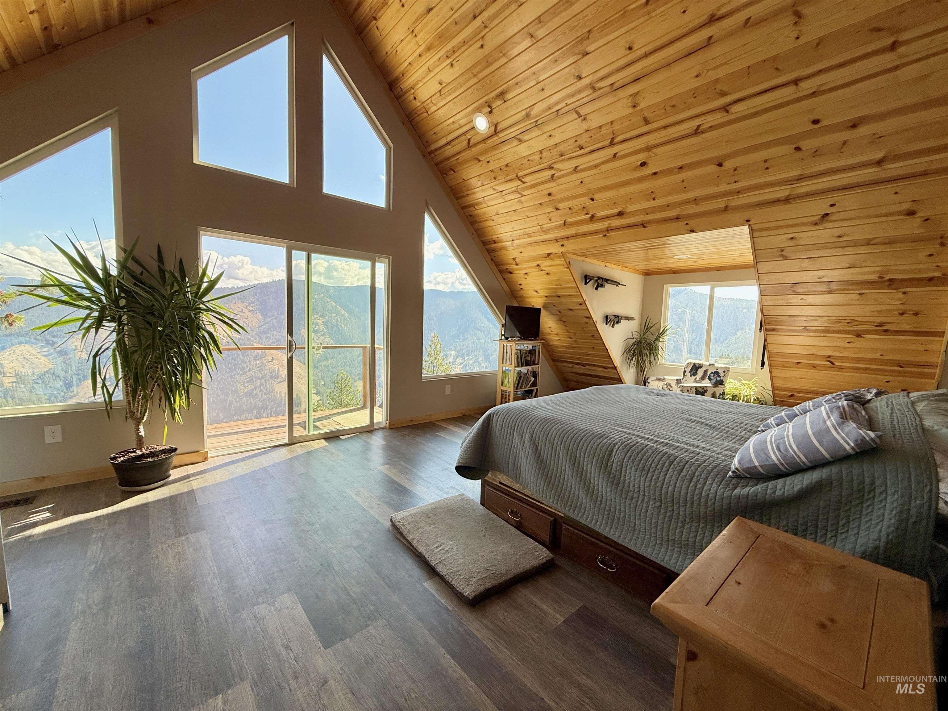 929 Mt Idaho Grade Road Grangeville, ID 83530 - Photo 15 of 47 Bedroom featuring high vaulted ceiling, access to outside, wood ceiling, wood finished floors, and wooden walls