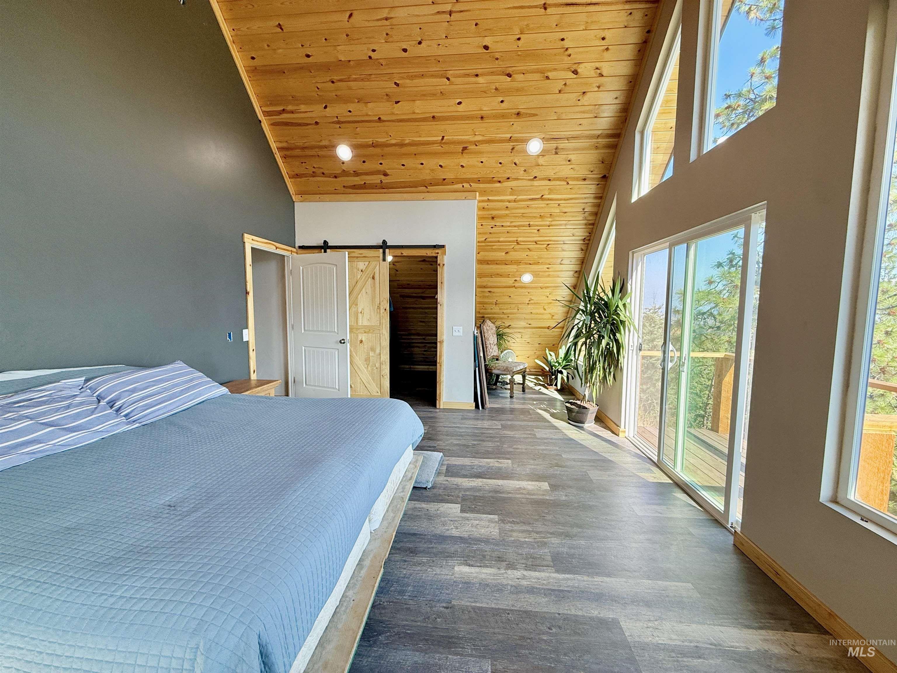 929 Mt Idaho Grade Road Grangeville, ID 83530 - Photo 16 of 47 Bedroom with a barn door, high vaulted ceiling, wood ceiling, wood finished floors, and recessed lighting