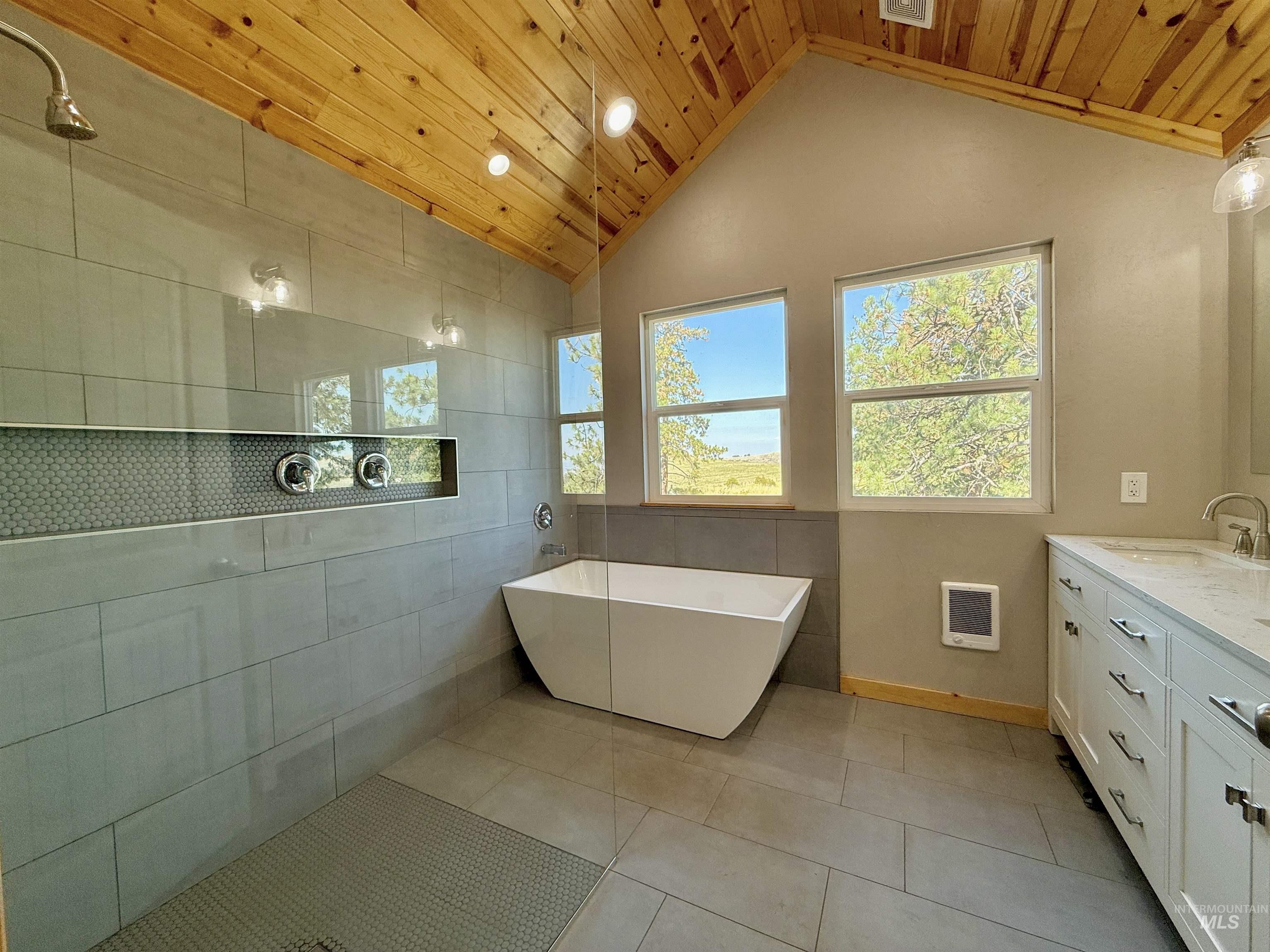 929 Mt Idaho Grade Road Grangeville, ID 83530 - Photo 17 of 47 Bathroom with a freestanding tub, vanity, vaulted ceiling, wood ceiling, and light tile patterned flooring