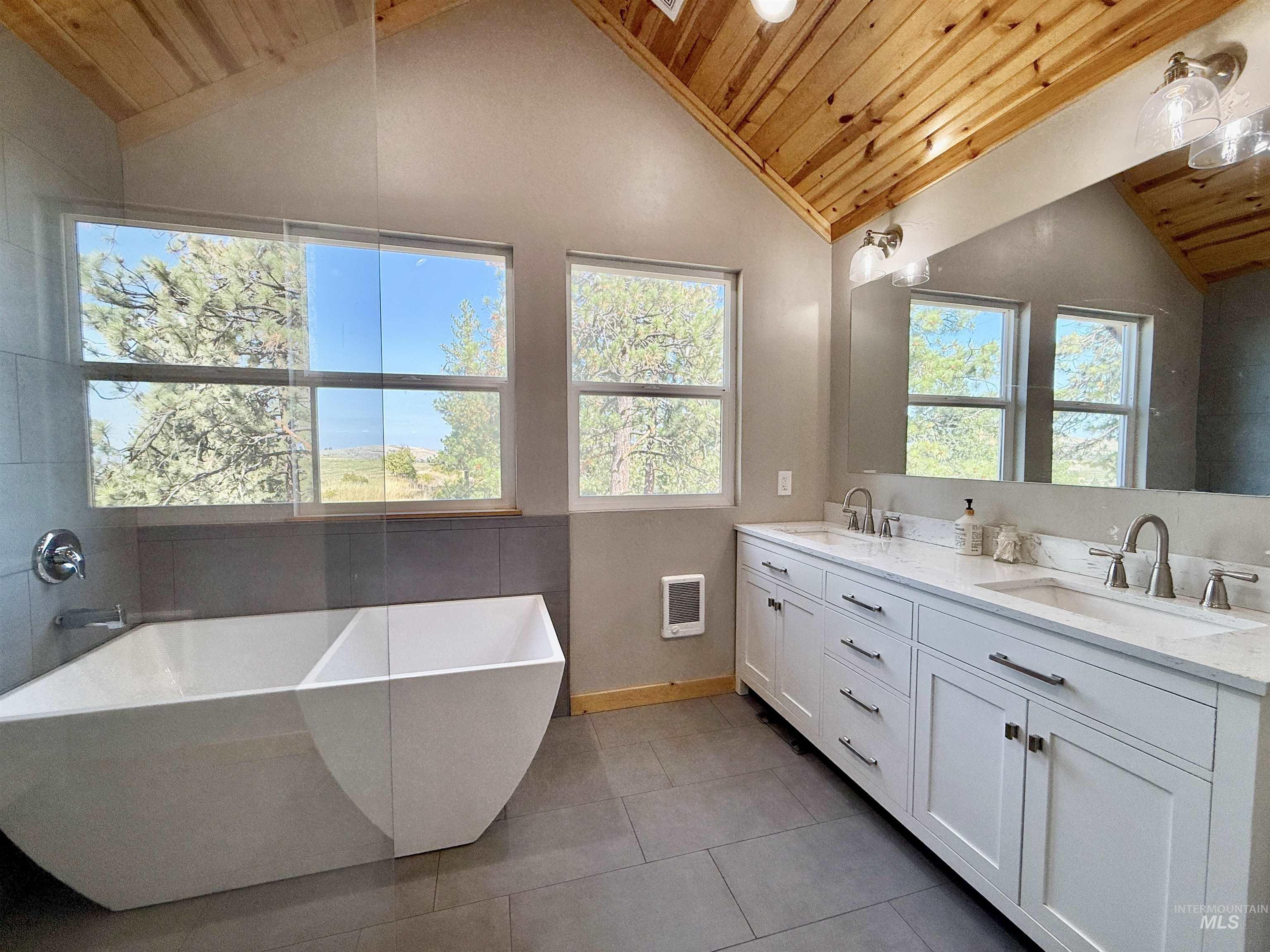 929 Mt Idaho Grade Road Grangeville, ID 83530 - Photo 18 of 47 Full bath featuring lofted ceiling, a soaking tub, wood ceiling, double vanity, and light tile patterned floors