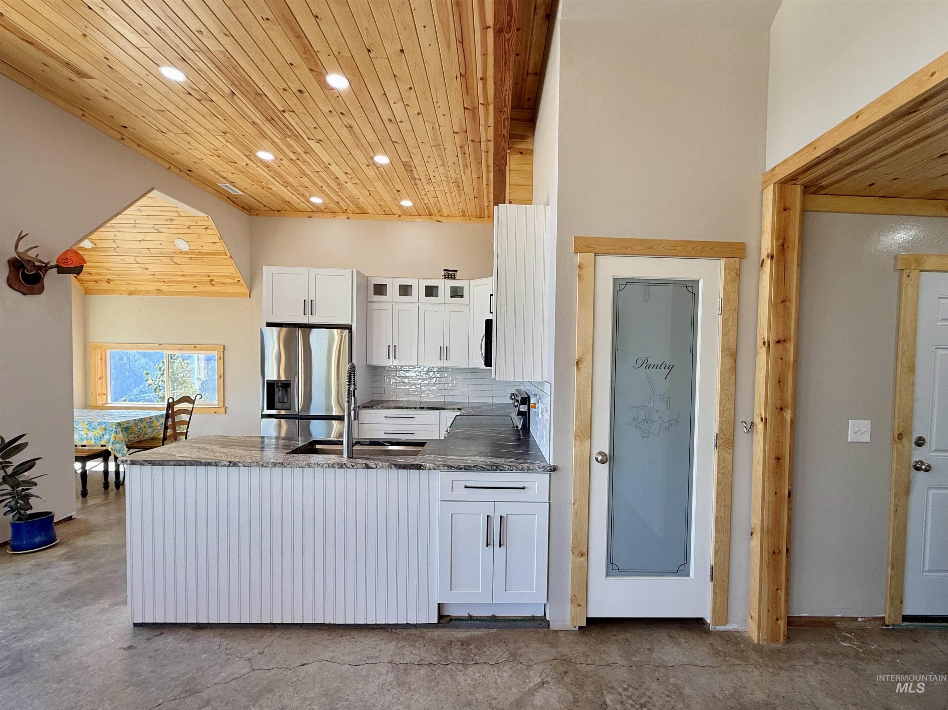 929 Mt Idaho Grade Road Grangeville, ID 83530 - Photo 8 of 47 Kitchen featuring wood ceiling, white cabinets, dark stone counters, tasteful backsplash, and recessed lighting