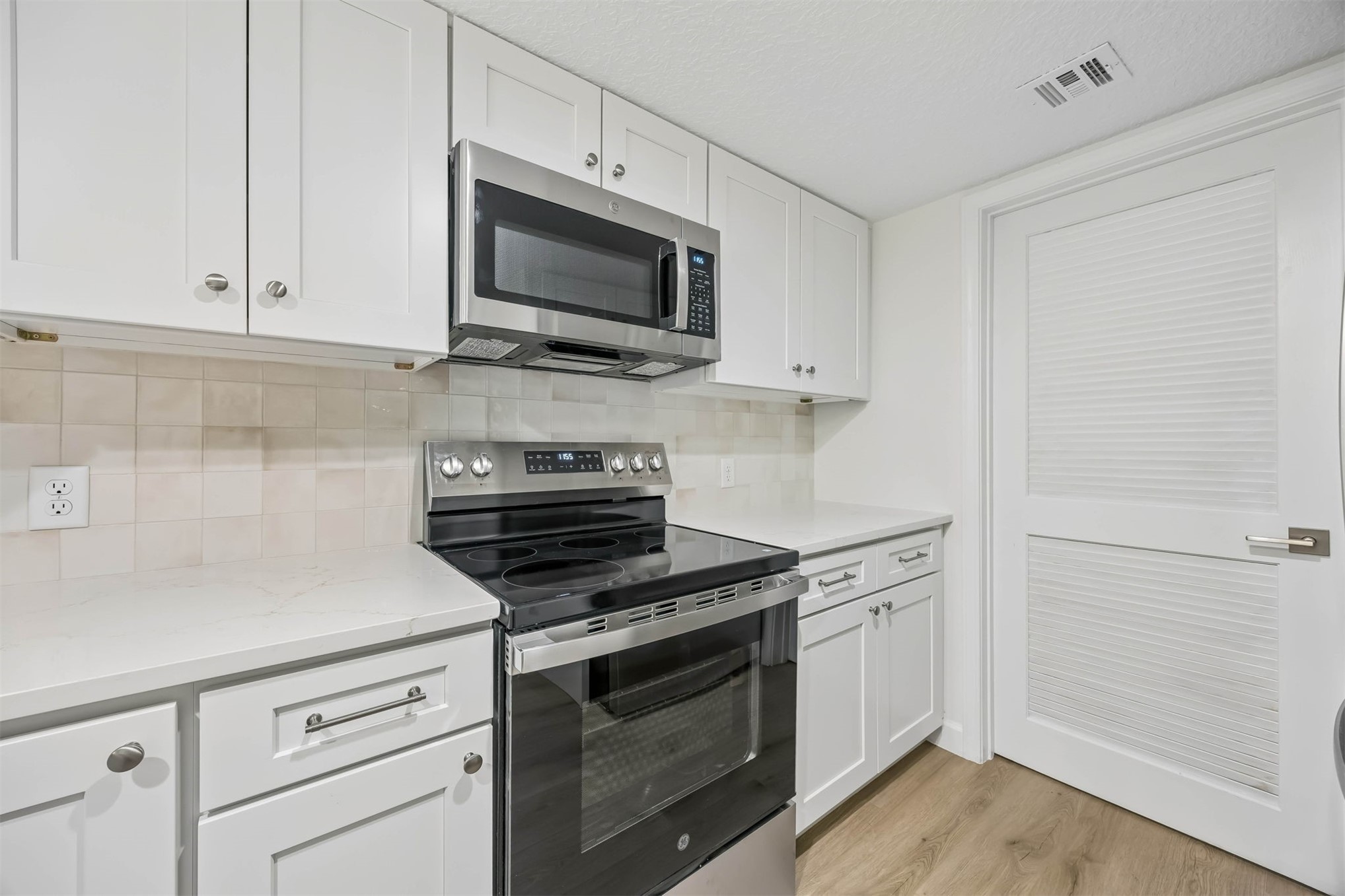 2109 Beachwood Road, Unit 2109 Fernandina Beach, FL 32034 - Photo 8 of 31 a kitchen with white cabinets and stainless steel appliances