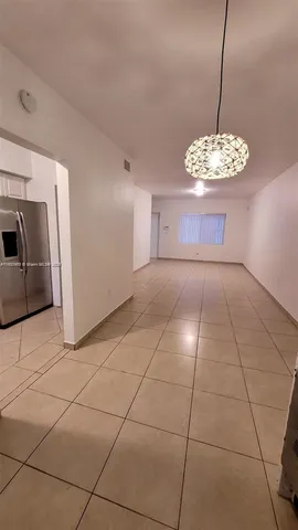 a view of a livingroom with a chandelier furniture and windows