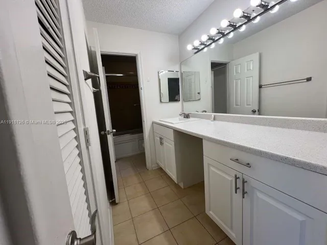 a spacious bathroom with a double vanity sink and mirror
