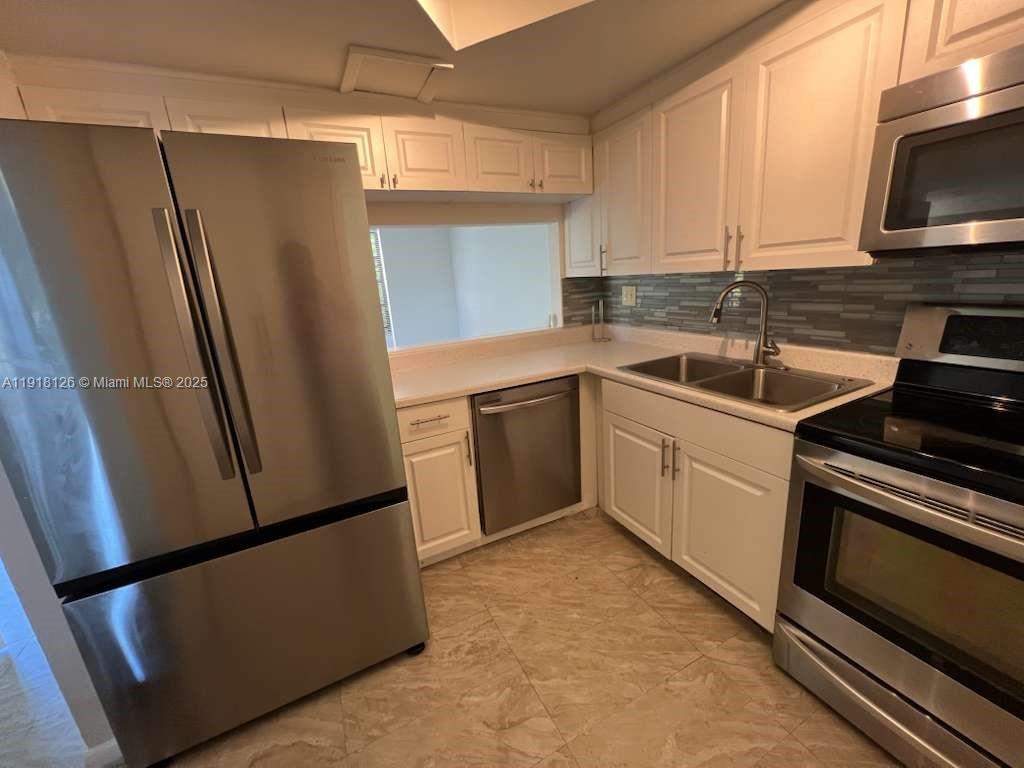 721 Southeast 1st Way, Unit B18 Deerfield Beach, FL 33441 - Photo 2 of 22 a kitchen with a sink appliances and cabinets