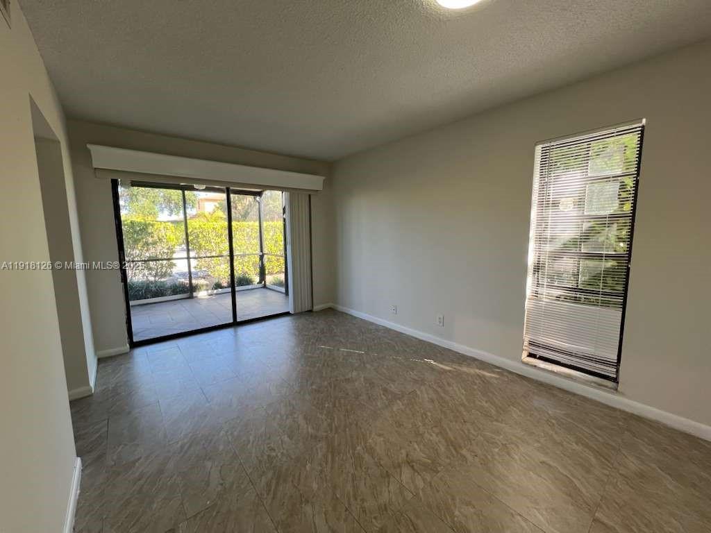 721 Southeast 1st Way, Unit B18 Deerfield Beach, FL 33441 - Photo 6 of 22 an empty room with wooden floor and windows
