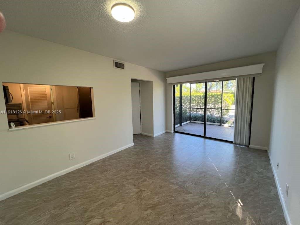 721 Southeast 1st Way, Unit B18 Deerfield Beach, FL 33441 - Photo 7 of 22 an empty room with wooden floor and windows