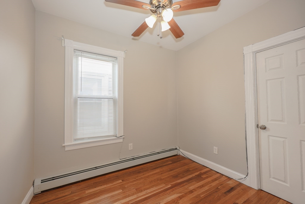 64 Bremen Street Boston, MA 02128 - Photo 14 of 42 an empty room with wooden floor closet and windows