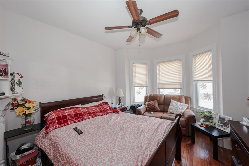 64 Bremen Street Boston, MA 02128 - Photo 23 of 42 a bedroom with a bed and a chandelier