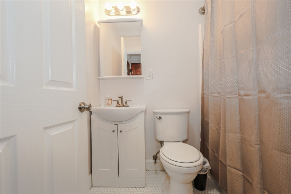 64 Bremen Street Boston, MA 02128 - Photo 27 of 42 a white toilet sitting next to a bathroom sink