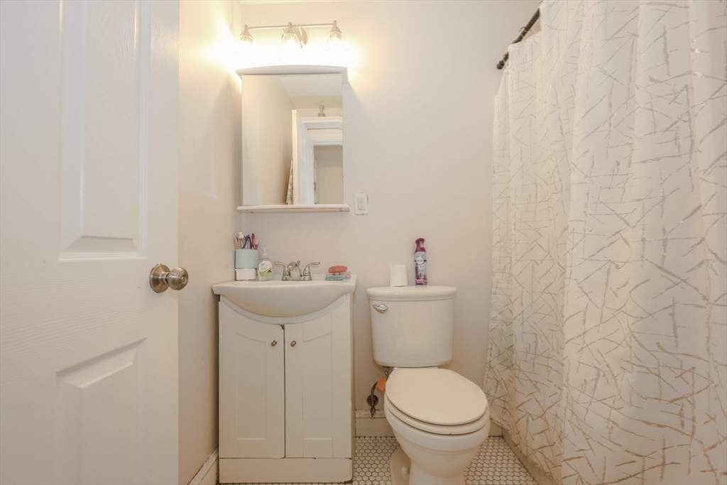 64 Bremen Street Boston, MA 02128 - Photo 31 of 42 a bathroom with a sink toilet and a mirror