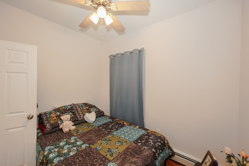 64 Bremen Street Boston, MA 02128 - Photo 33 of 42 a bedroom with a bed and a chandelier fan