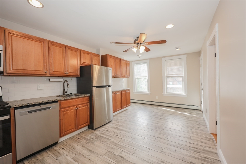 64 Bremen Street Boston, MA 02128 - Photo 6 of 42 a kitchen with stainless steel appliances granite countertop a refrigerator a sink dishwasher and a stove with wooden floor