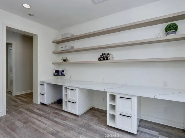 a bedroom with a bed and a dresser with wooden floor