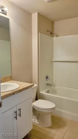 a bathroom with a granite countertop sink toilet a shower and a mirror
