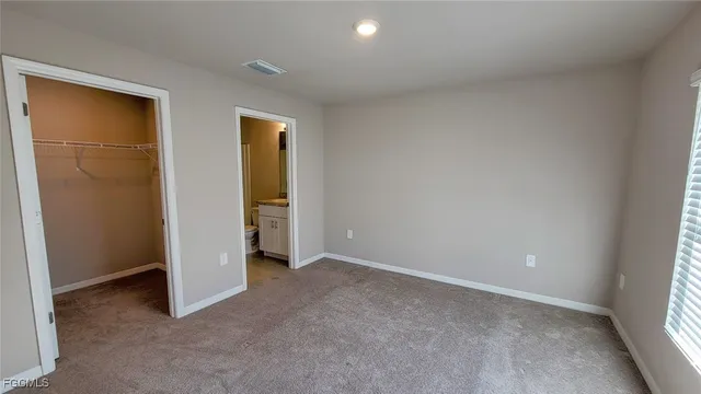 an empty room with closet and a window