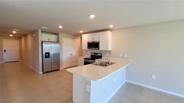 a kitchen that has a sink a refrigerator and a stove top oven