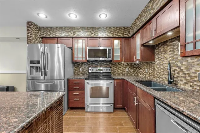 a kitchen with granite countertop a sink and cabinets