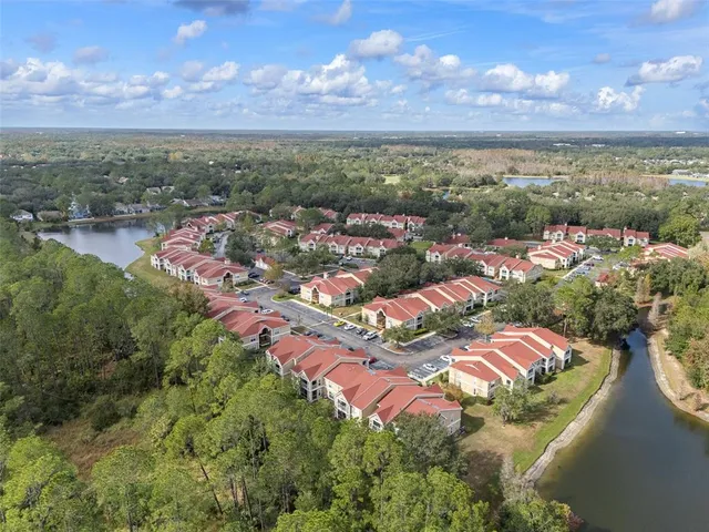 an aerial view of residential houses with outdoor space and lake view