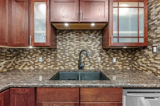 a kitchen with stainless steel appliances granite countertop a refrigerator a sink and a stove