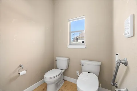 a white toilet sitting next to a bathroom sink and a mirror