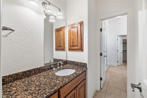 a bathroom with a granite countertop sink and a mirror
