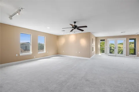 a view of a room with a ceiling fan and windows