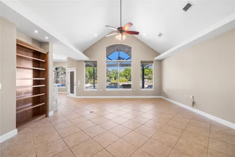 a view of an empty room with a window and cabinets
