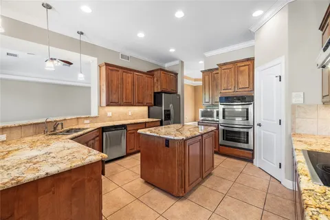 a kitchen with stainless steel appliances granite countertop a sink stove and refrigerator