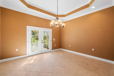 a view of a livingroom with a chandelier fan and a window