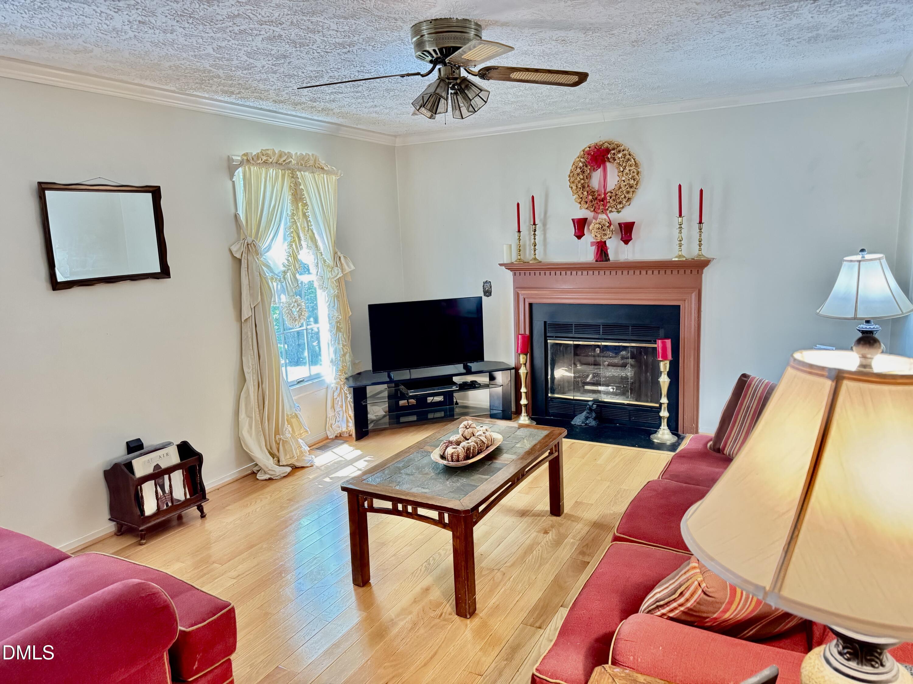 84 Wintergreen Road Henderson, NC 27537 - Photo 7 of 49 a living room with furniture a flat screen tv and a fireplace