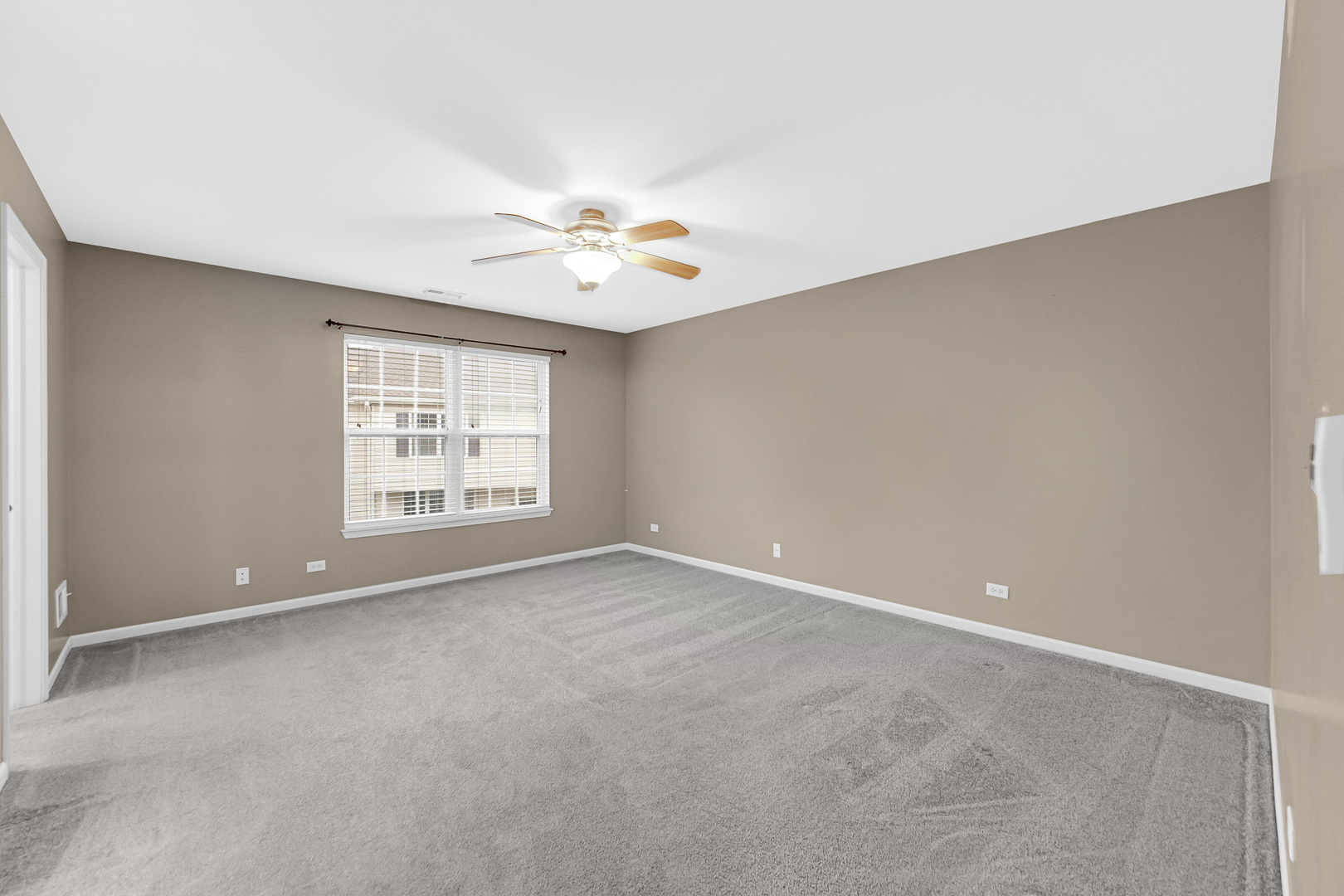 2331 Georgetown Circle Aurora, IL 60503 - Photo 12 of 20 an empty room with windows and chandelier fan