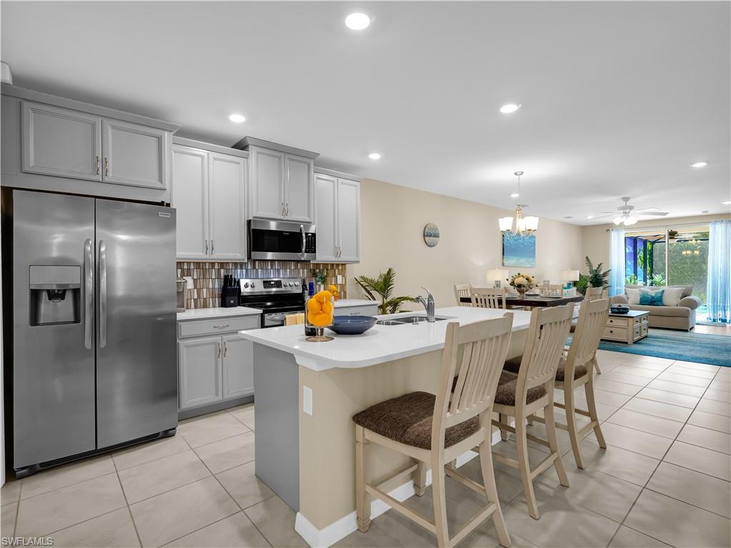14695 Edgewater Circle Naples, FL 34114 - Photo 9 of 39 a kitchen with stainless steel appliances a refrigerator sink and microwave