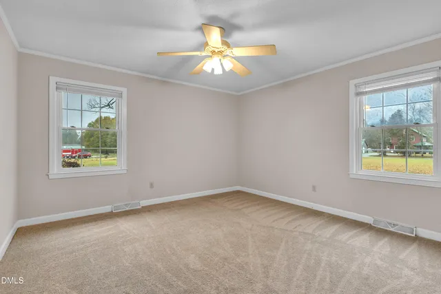 an empty room with window and chandelier fan