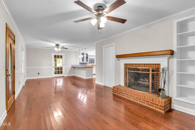 a view of empty room with wooden floor and fireplace