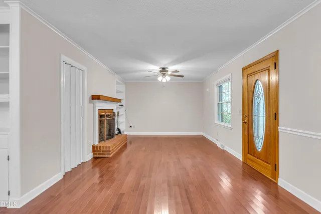 a view of a livingroom with wooden floor and a ceiling fan