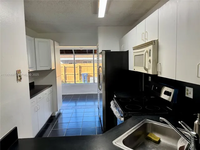 a kitchen with granite countertop a stove and a refrigerator