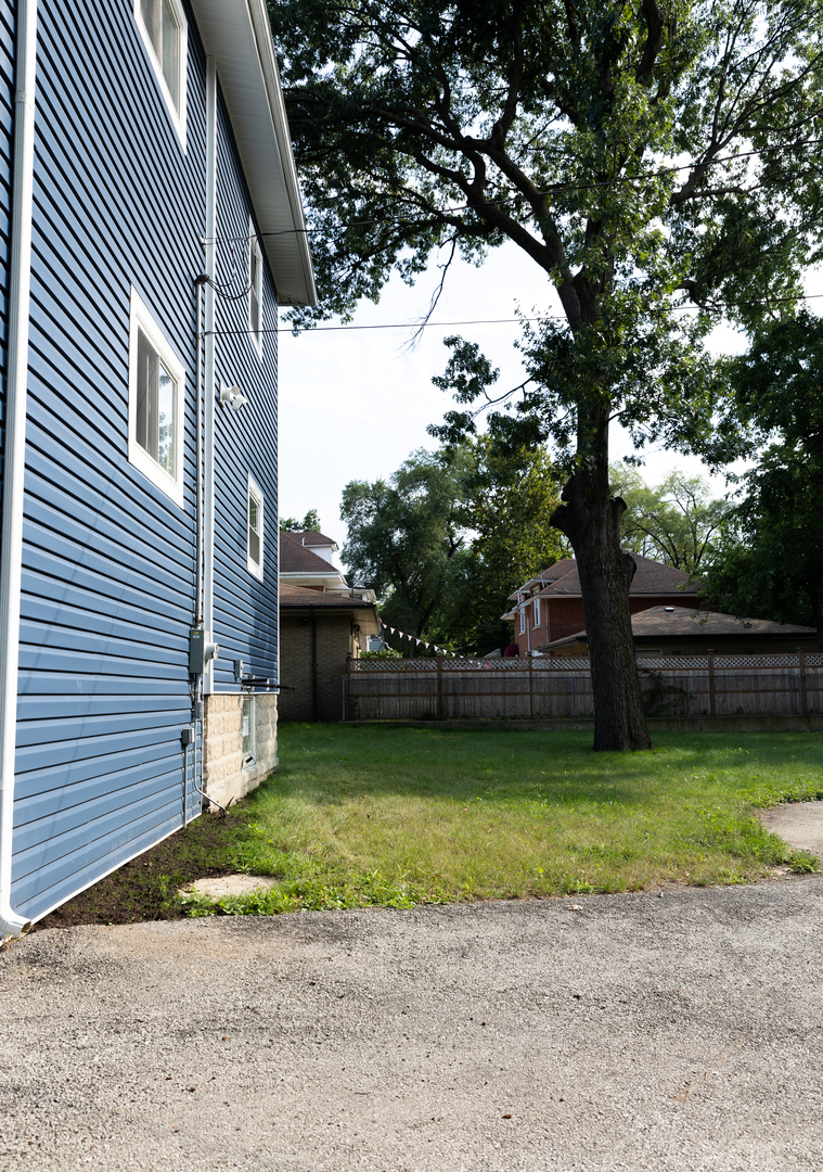 12124 South Stewart Avenue Chicago, IL 60628 - Photo 5 of 71 a view of a backyard with a large tree