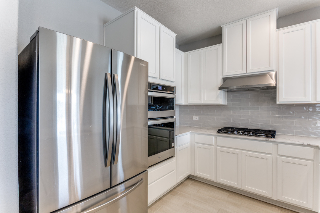 1100 Desaix Drive Georgetown, TX 78628 - Photo 11 of 25 a kitchen with stainless steel appliances white cabinets and a refrigerator