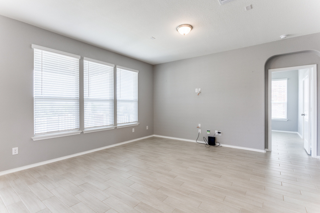1100 Desaix Drive Georgetown, TX 78628 - Photo 14 of 25 an empty room with wooden floor and windows
