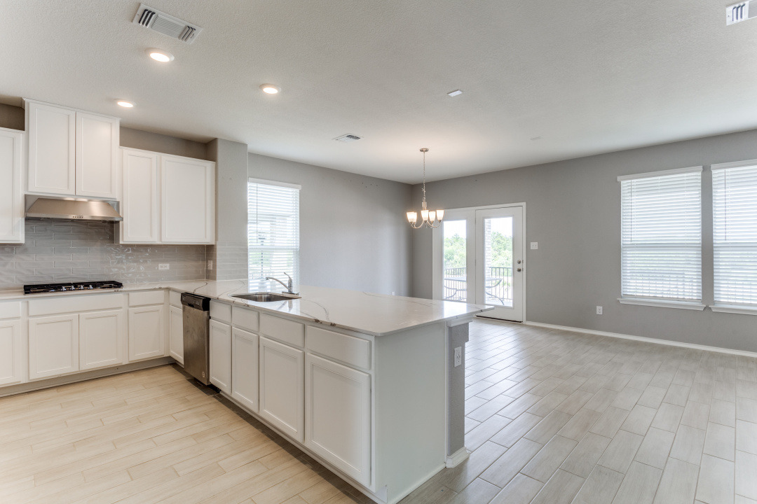 1100 Desaix Drive Georgetown, TX 78628 - Photo 7 of 25 a large kitchen with stainless steel appliances granite countertop a stove a sink and white cabinets
