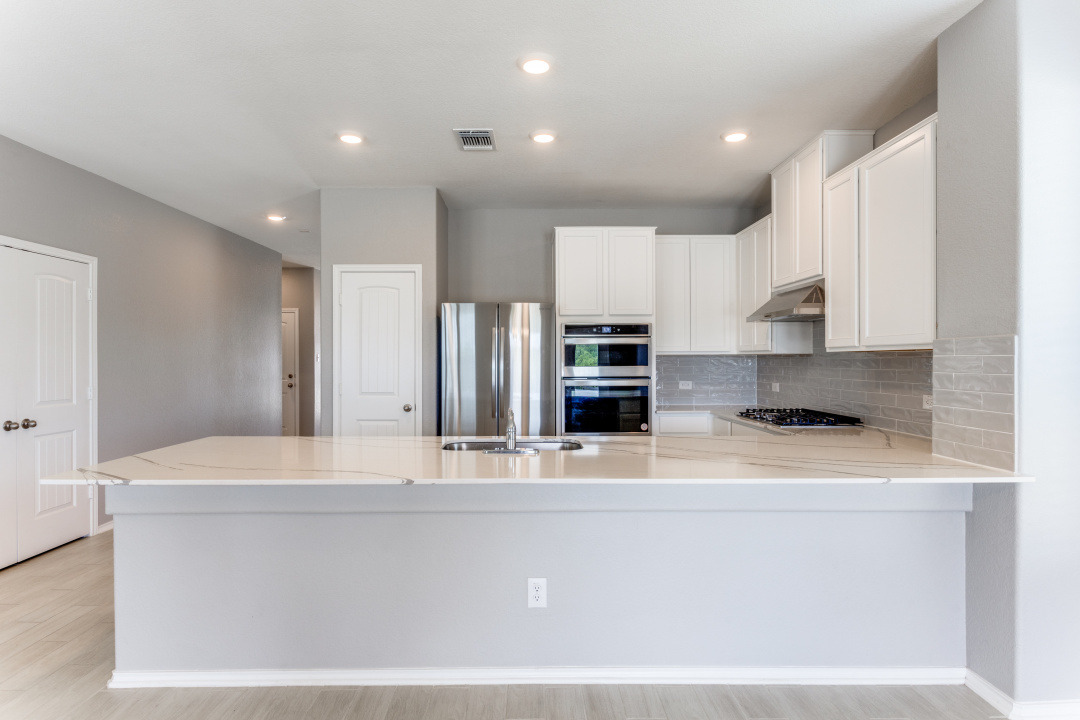 1100 Desaix Drive Georgetown, TX 78628 - Photo 9 of 25 a view of a kitchen with center island and stainless steel appliances