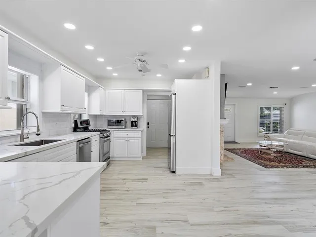 a kitchen with white cabinets and stainless steel appliances